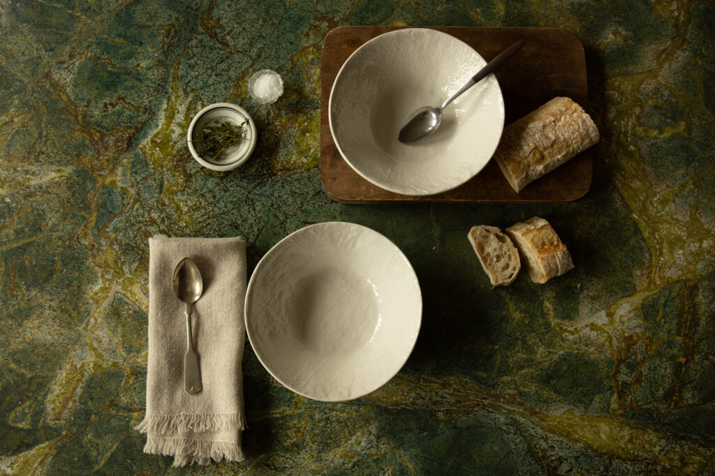 Table setting for two on green marble background